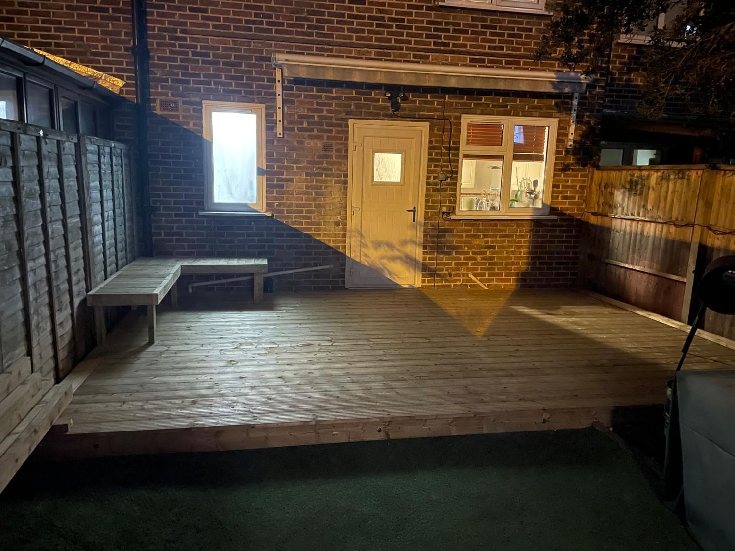 Completed garden decking project lit at night